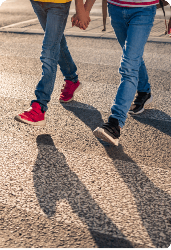 the legs of two boys crossing the road