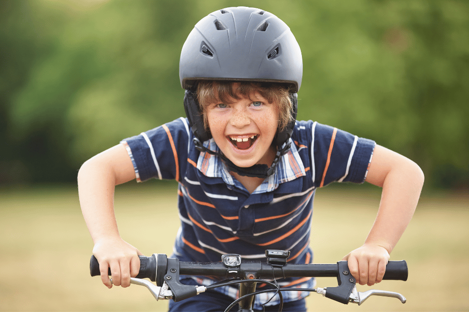 a boy happily riding a bicycle
