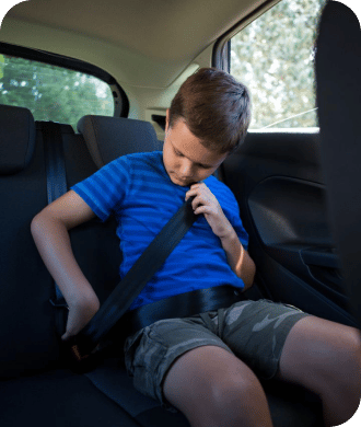 a boy trying to fasten his seat belt