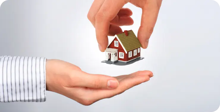 a person handing someone a small house