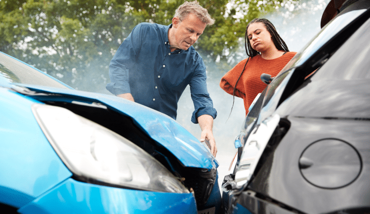 two drivers looking at damaged cars