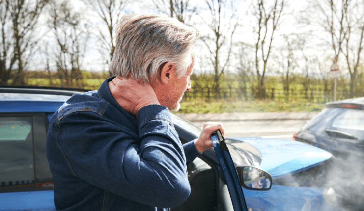 a man holding his neck after a car wreck